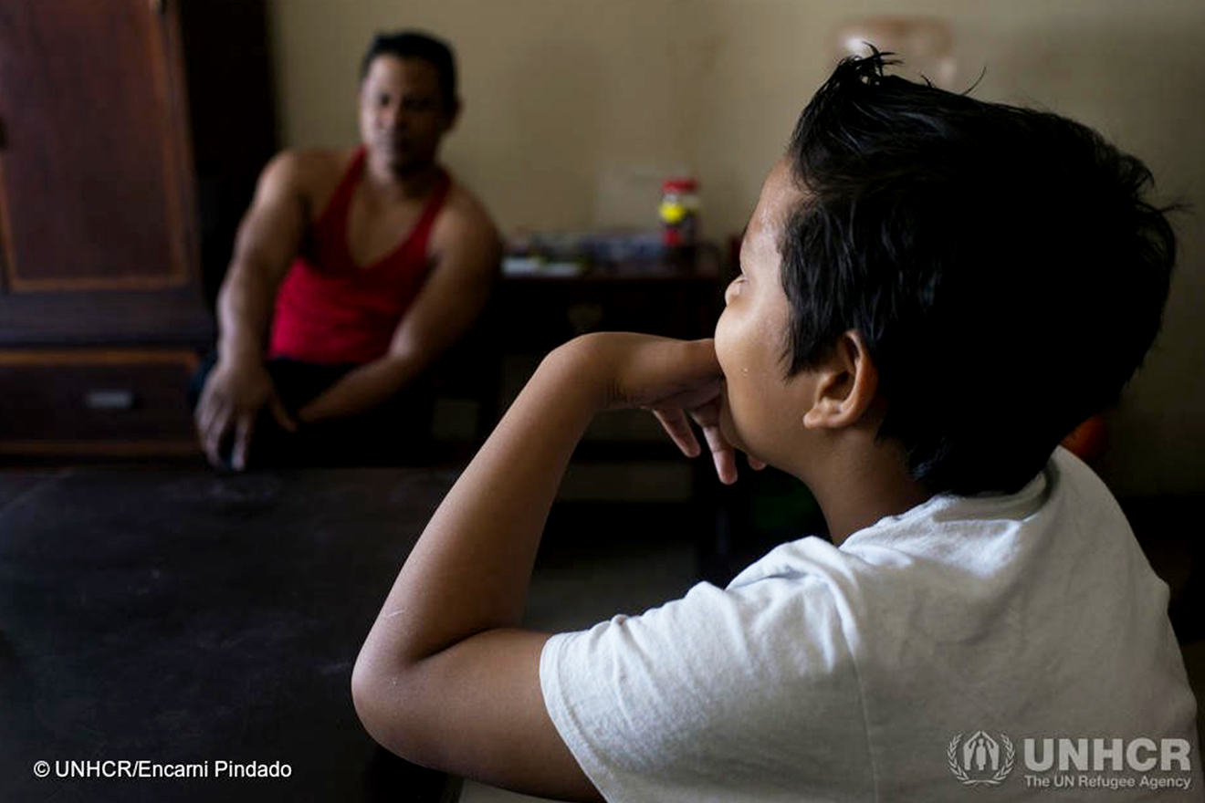 A Guatemalan boy speaks with his father in Mexico, where they were granted asylum after fleeing gang violence back home.