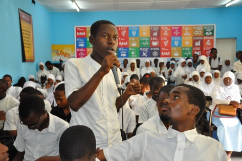 A student poses a question at the commemorative briefing