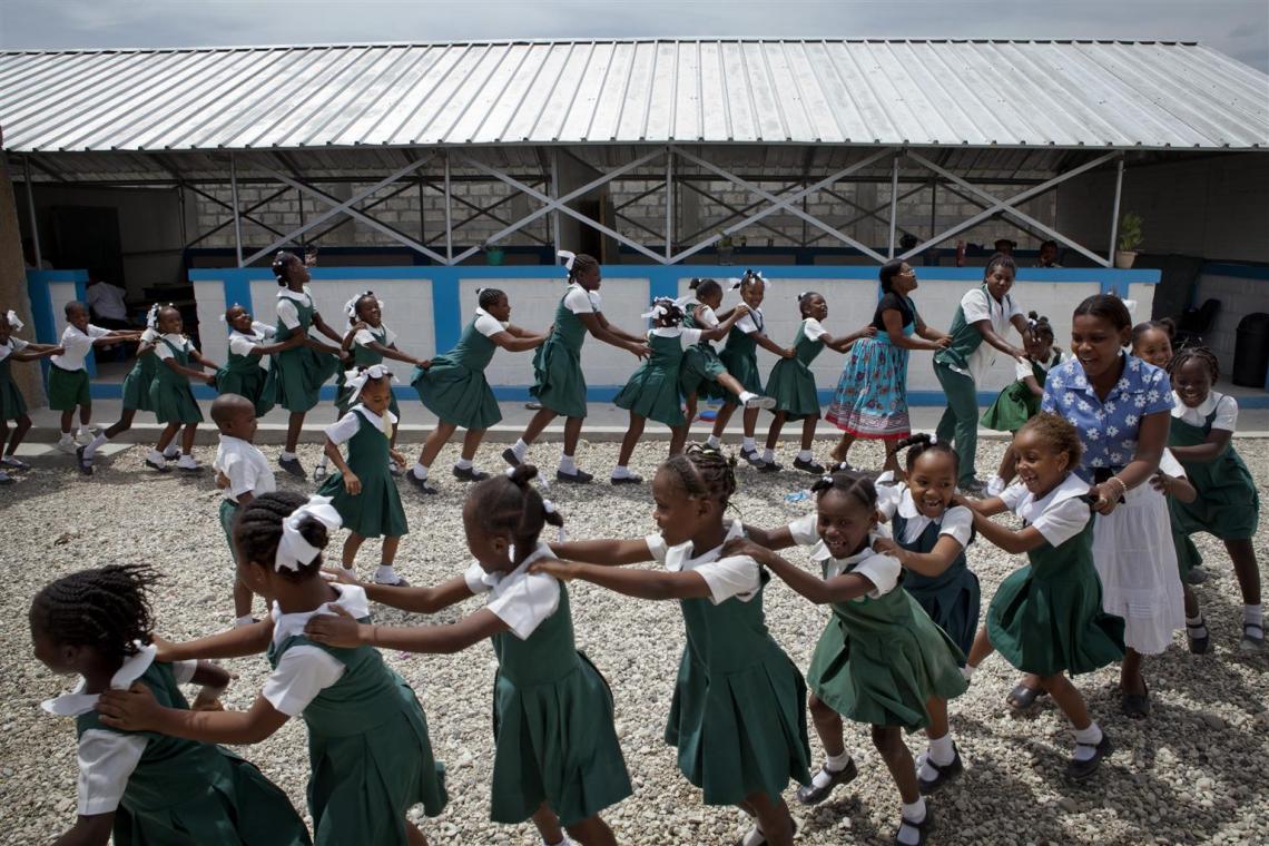 Les élèves jouent devant la maternelle et l'école primaire Mamalu à Port-au-Prince, en Haïti. L'école, qui s'est effondrée pendant le tremblement de terre, a été reconstruite par l'UNICEF en une installation semi-permanente.