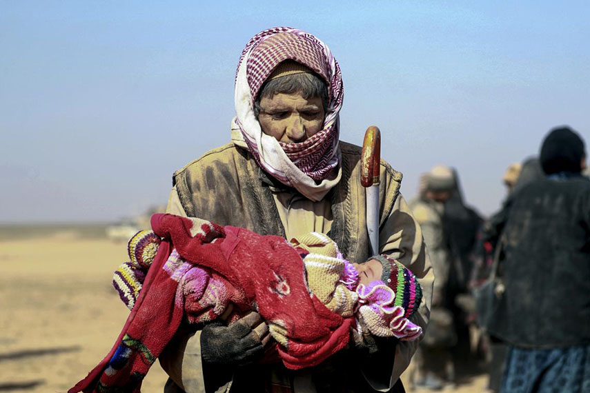 A man carries a small child in Syria