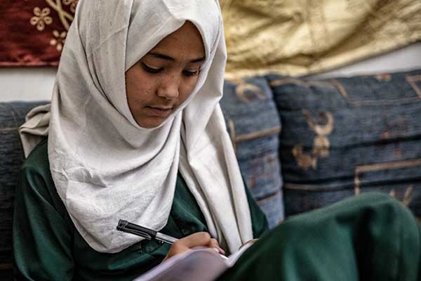 Une fille fait ses devoirs à la maison au Yémen. 