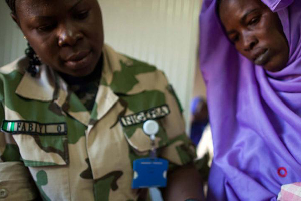 A peacekeeper attending a woman in East Darfur.