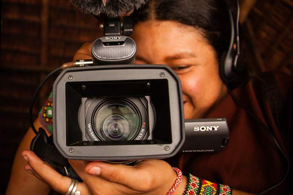 Woman holding camera with boom microphone.