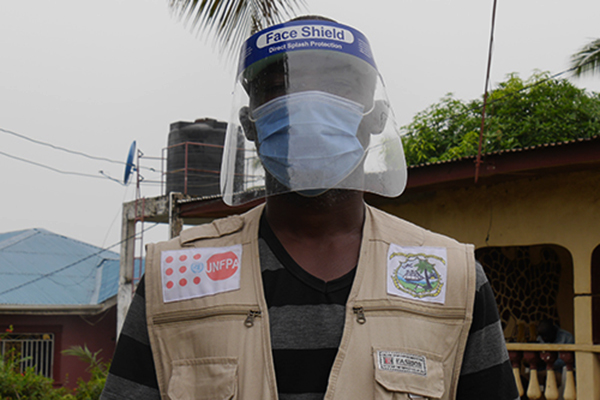 Portrait of a man with a mask and a face shield.