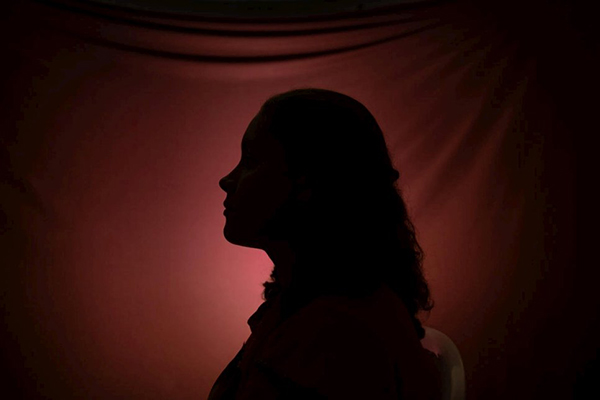 Silhouette of woman's profile in front a red light