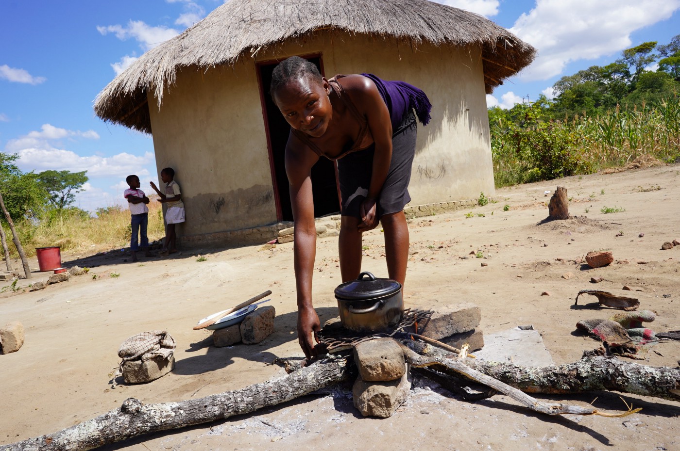 woman preparing food on wood fire