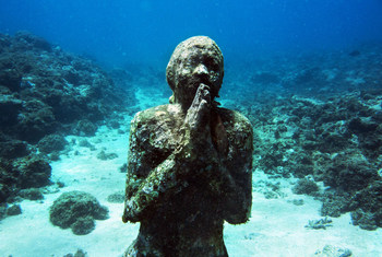Statue of a person praying located under the sea.UNEP/NOOR/Kadir van Lohuizen.