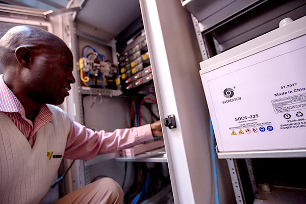 Man in front of a power source in Zimbabwe.