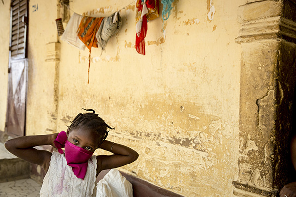 A girl wrapping a piece of cloth around her face.