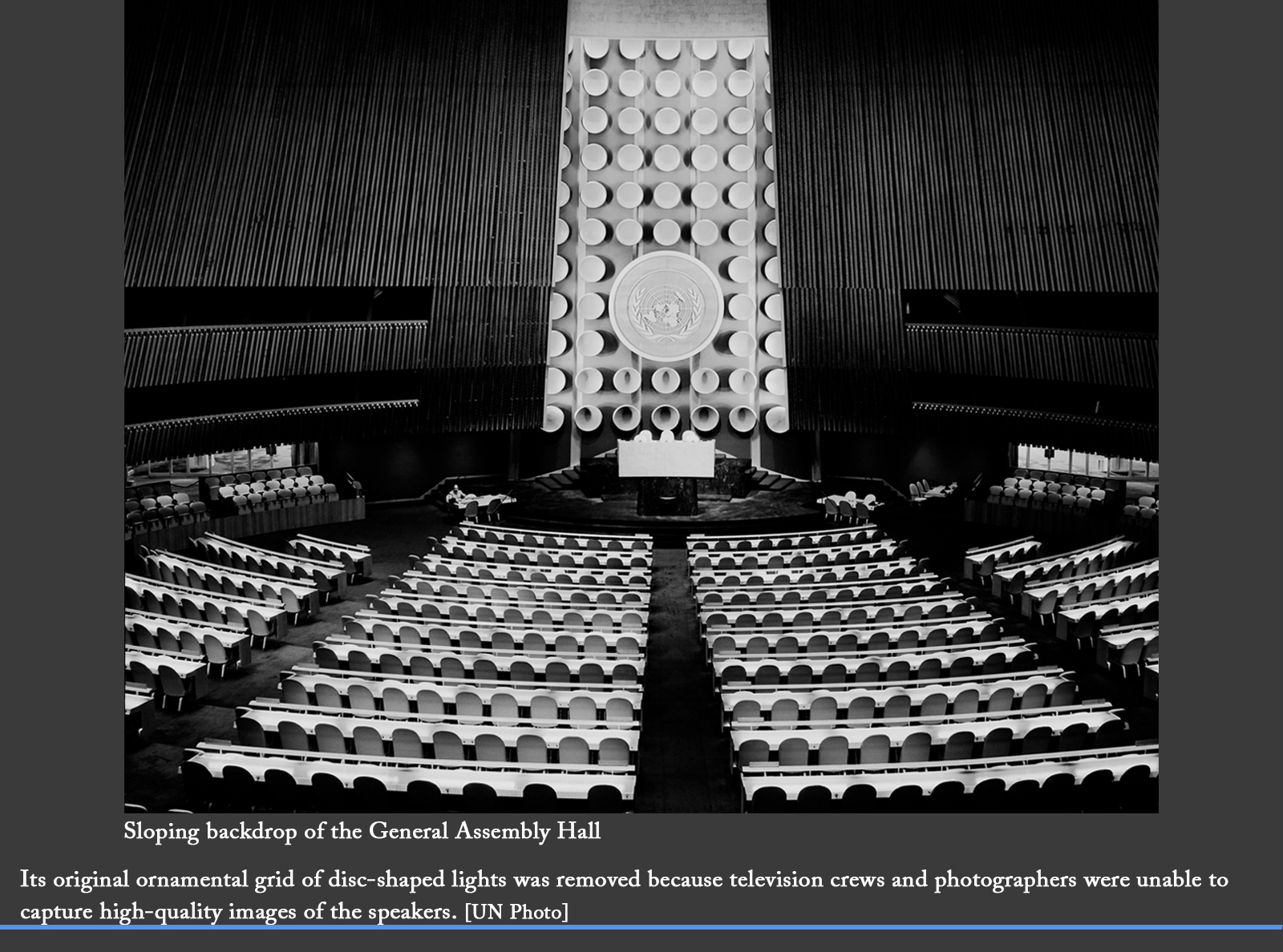 The sloping backdrop of the General Assembly Hall with its original ornamental grid of disc-shaped lights. They were removed because television crews and photographers were unable to capture high-quality images of the speakers.