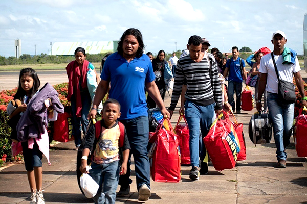 A group of people carrying bags walk toward the camera. 