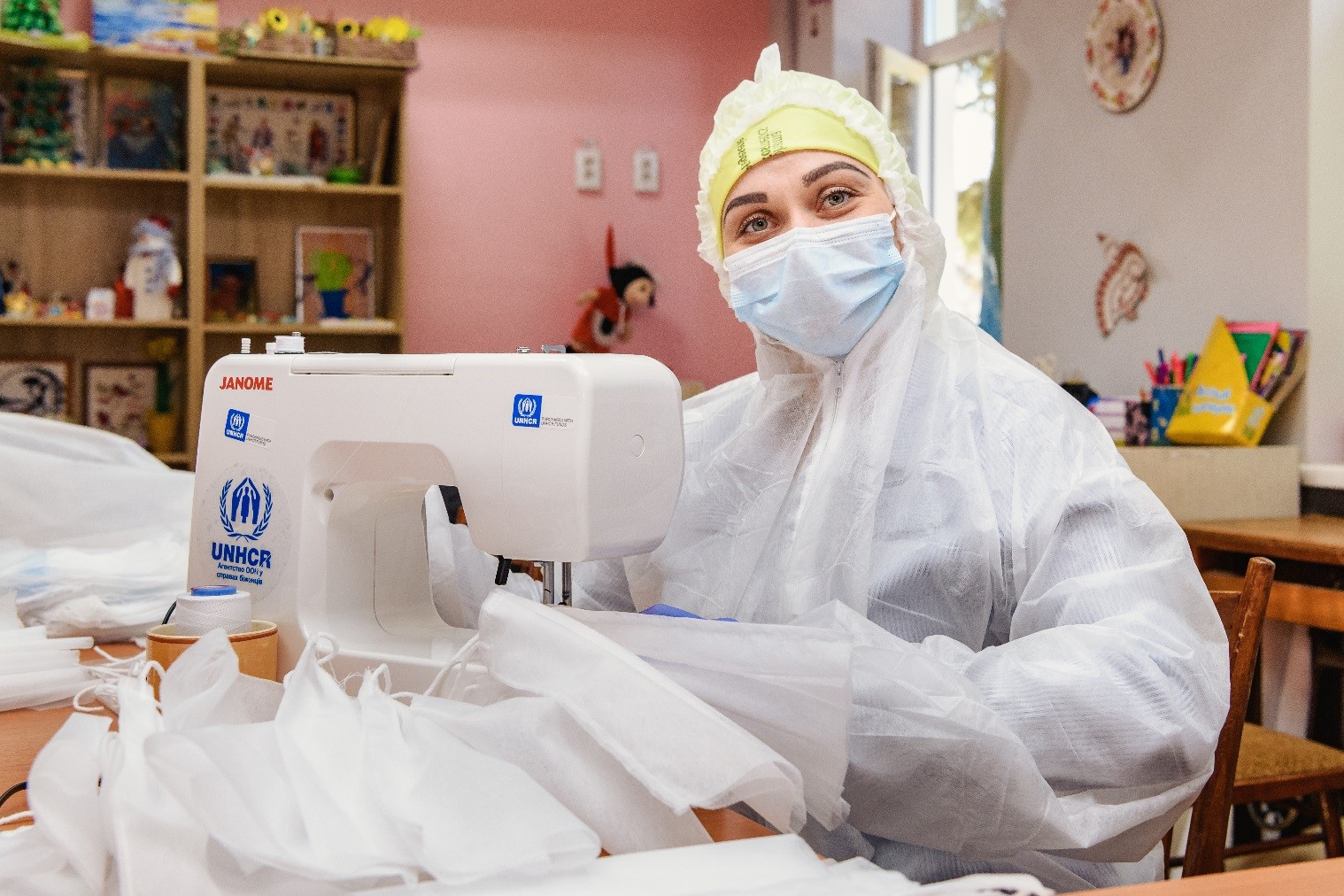 Une femme fabrique des masques à l’aide d’une machine à coudre.