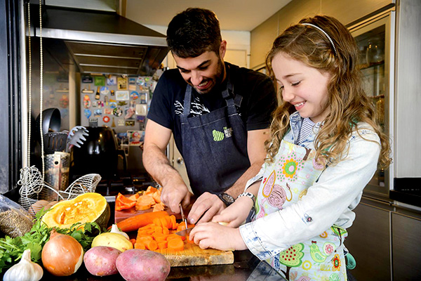 A girl preparing food with her father.