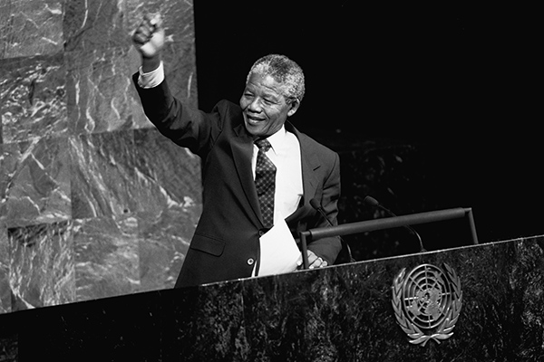 Nelson Mandela raises his fist up in the air in the General Assembly Hall.