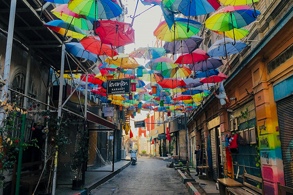 Empty street lined with colourful umbrellas.