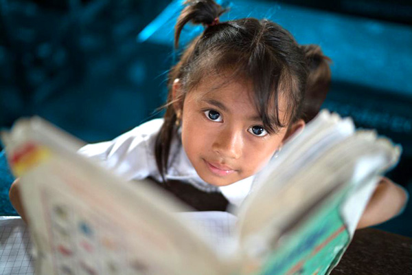 A girl looks up from her book. 