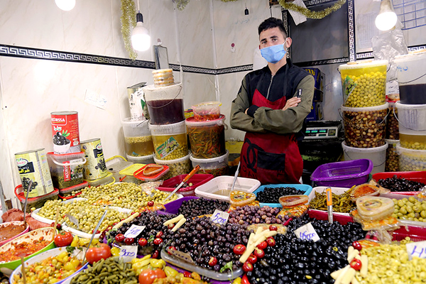 Man stands at fruit and vegetable stand