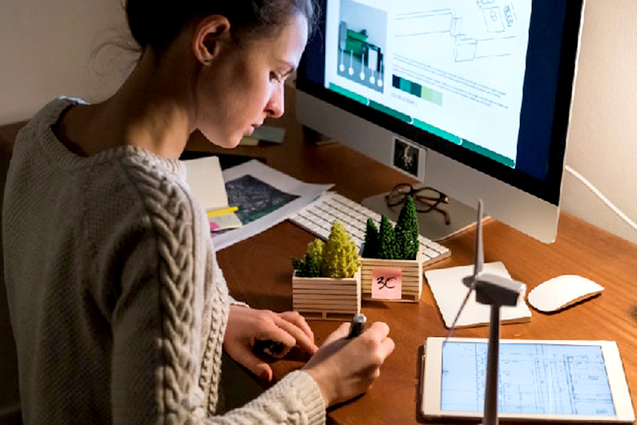 Girl working at a desk in front of a computer.