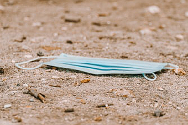 A facemask on the ground as trash.