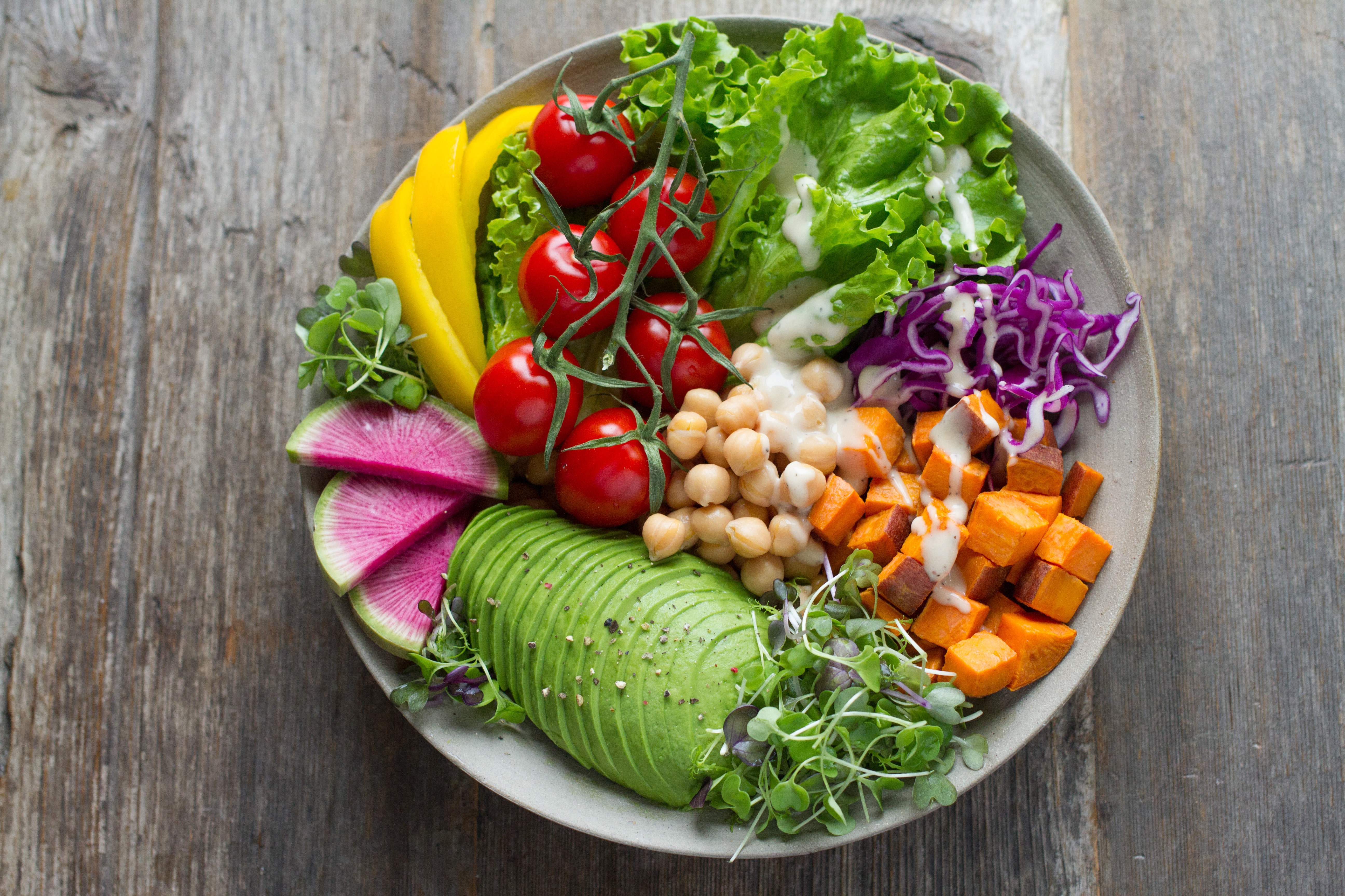 Plate with fresh vegetables and dressing