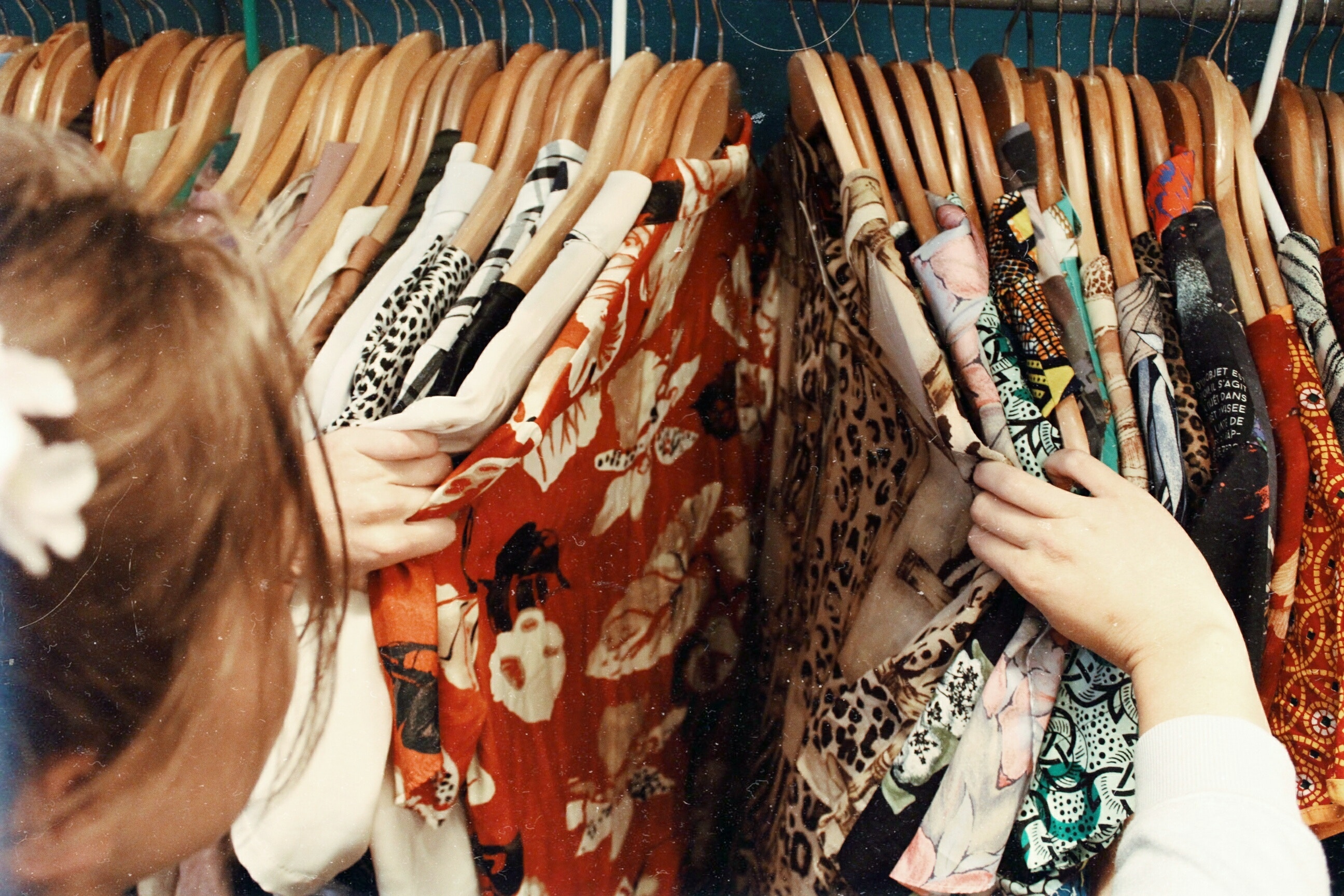A woman looks through a rack of dresses