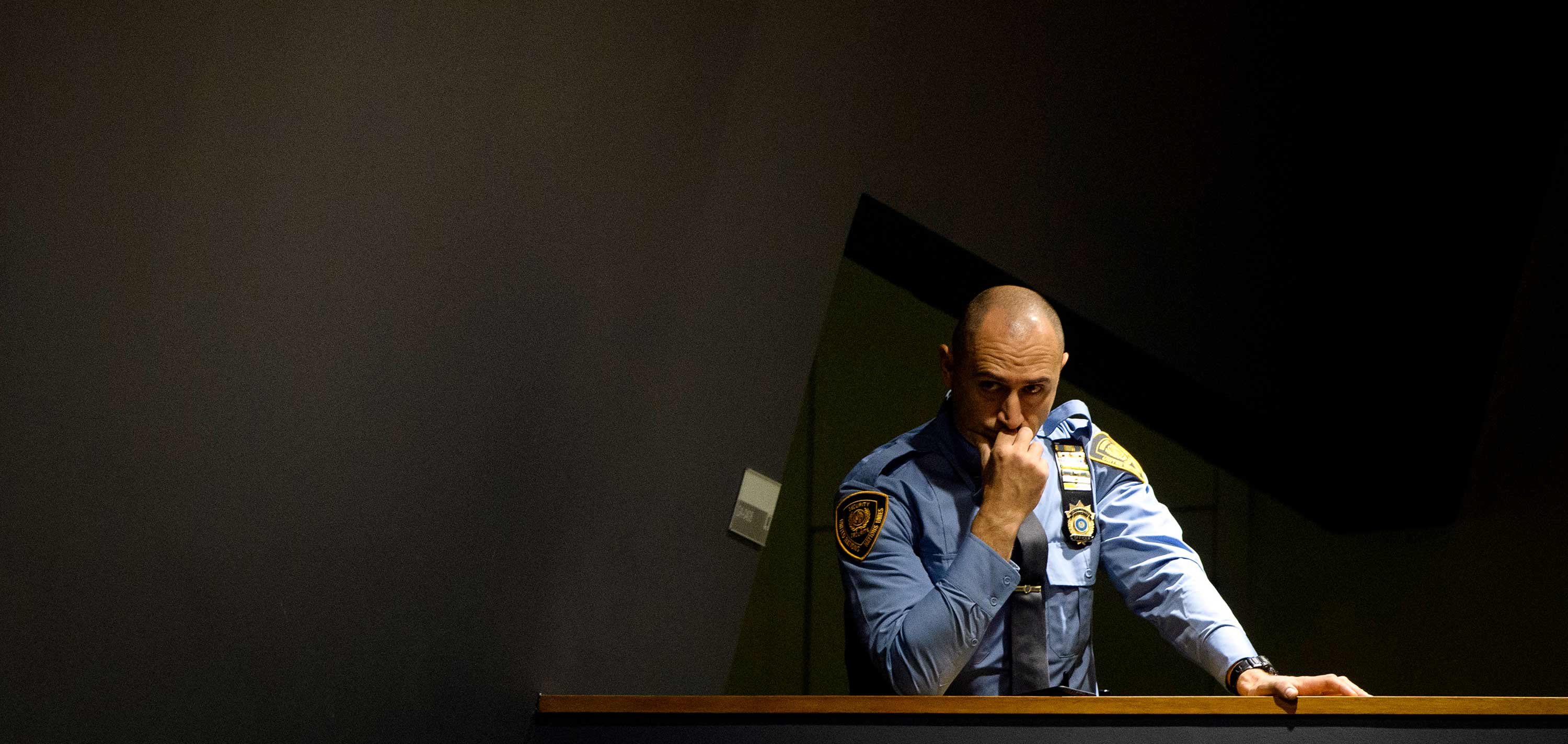 A Safety and Security officer looks on proceedings with a stressed look on his face.