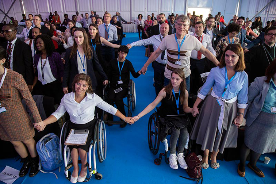 People in an audience holding hands. 