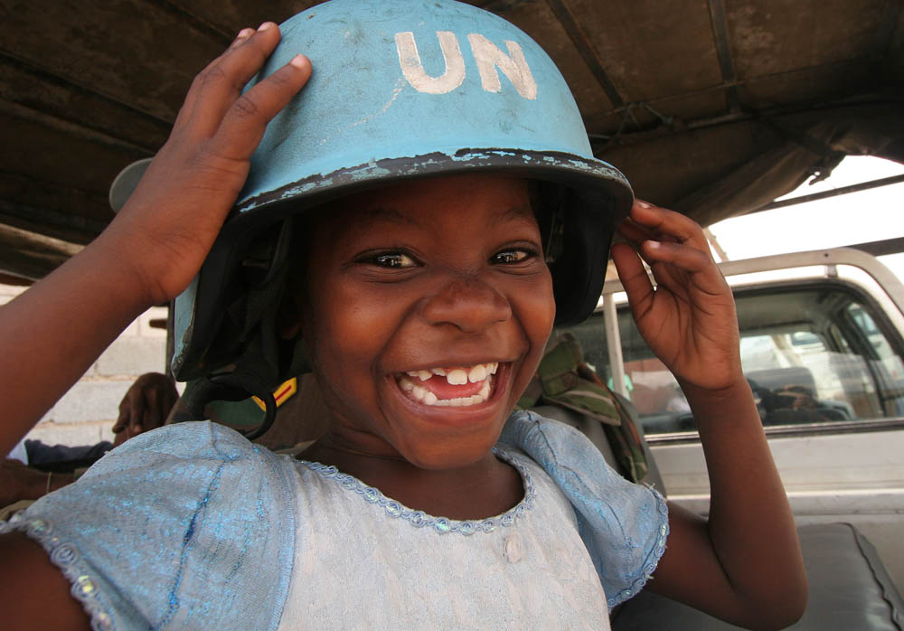 Young girl wearing UN blue helmet