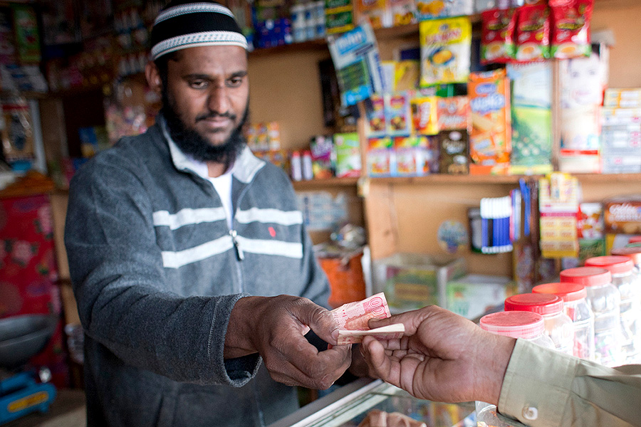 One billion people – 15 per cent of the world’s population – currently have a disability. Photo: IFAD A man takes money from behind a counter.