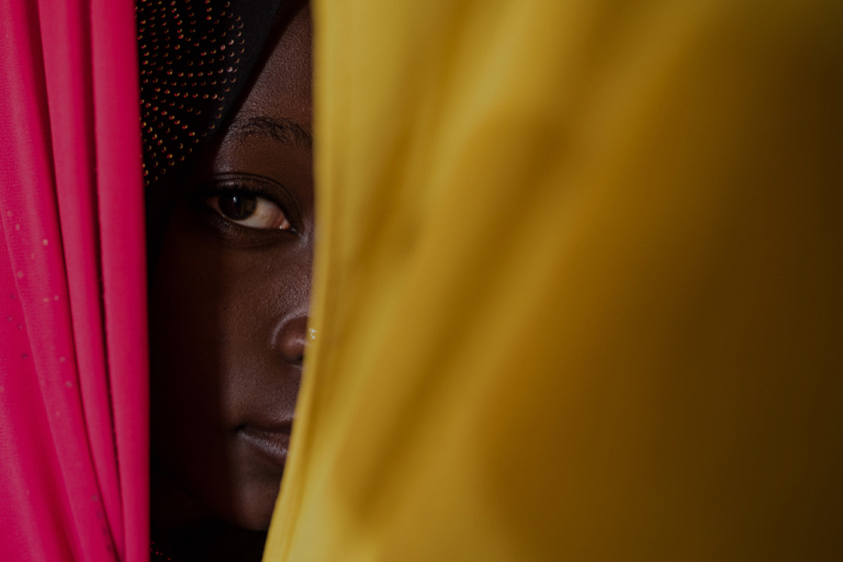 woman looking out from behind drapes