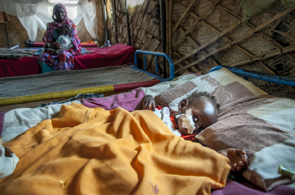 A malnourished child awaits care in the relative safety of a refugee camp in El Fasher, Sudan.