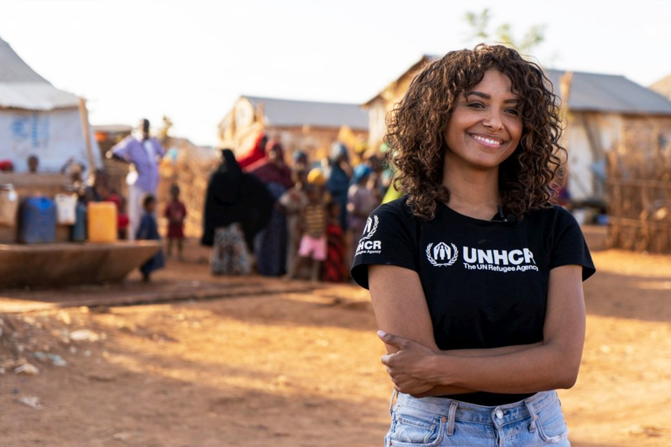 Kat Graham wearing a t-shirt that says "UNHCR".