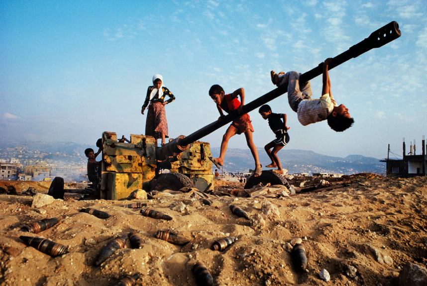 Make-believe conquers the tools of war as children clamber over an abandoned anti-aircraft gun.