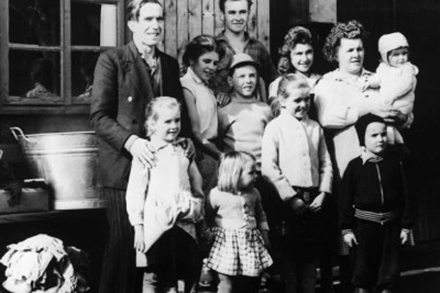 A black and white photo portraying a family with children of all ages. 