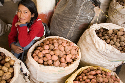 a woman sitting among bags of potatoes