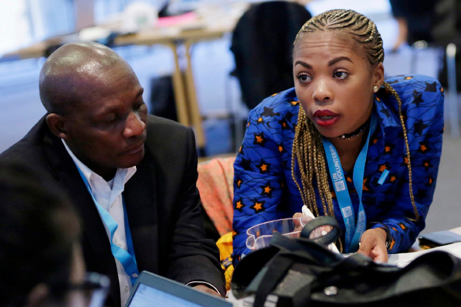 A man and a woman sit side-by-side at a meeting.