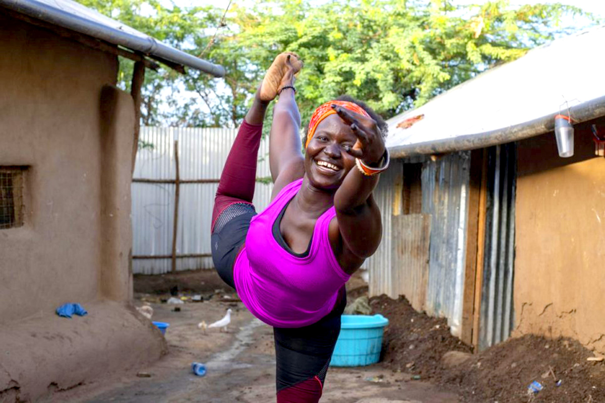 A woman doing the dancer yoga pose. 