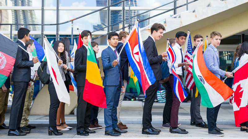 在联合国总部举行的一年一度的和平钟仪式上，手举会员国国旗的学生们。