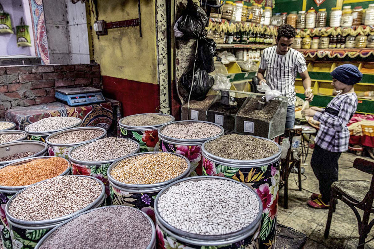 A shop seller selling beans in a market stand in Cairo.