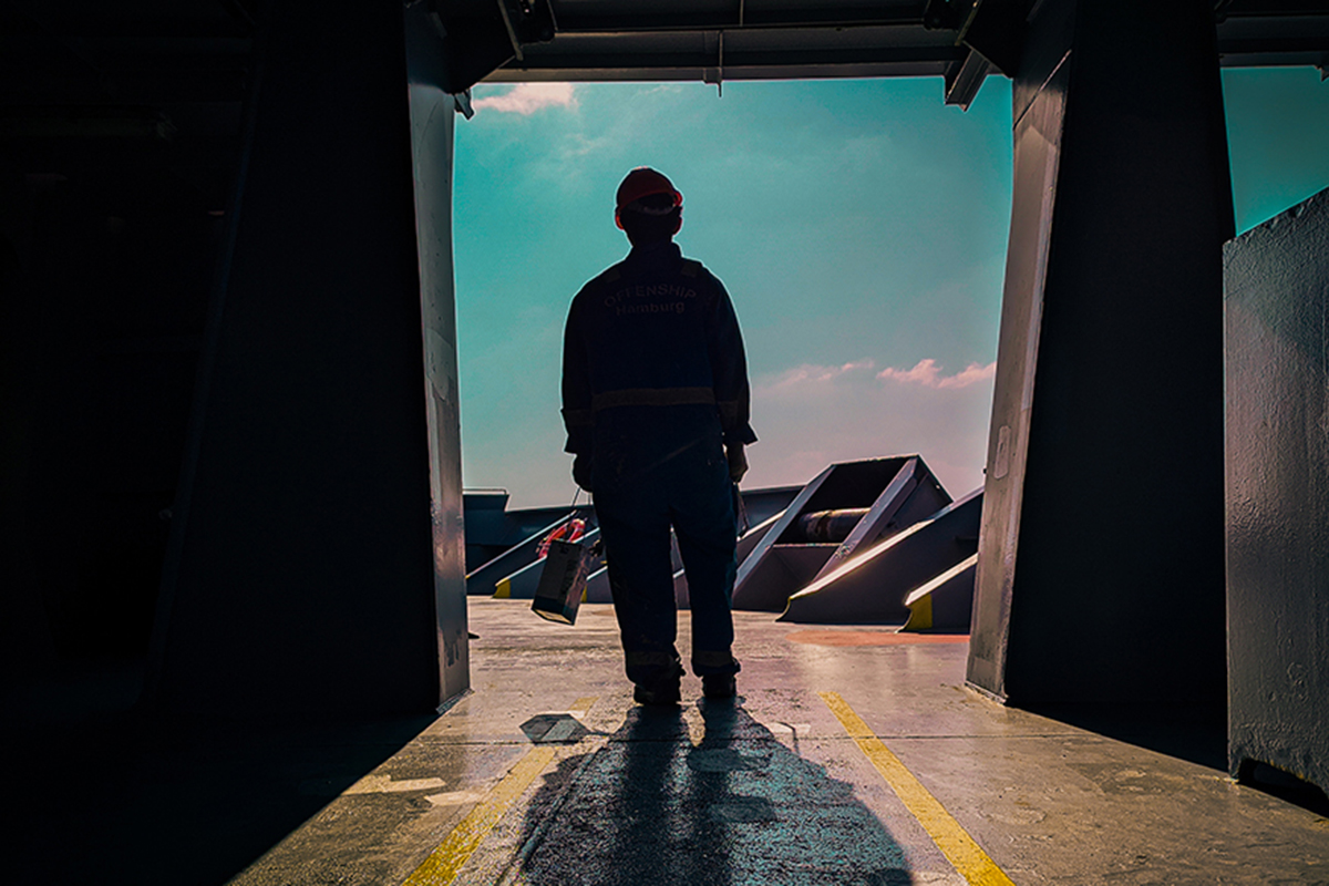 silhouette of a man standing at the entrance to the deck of a ship