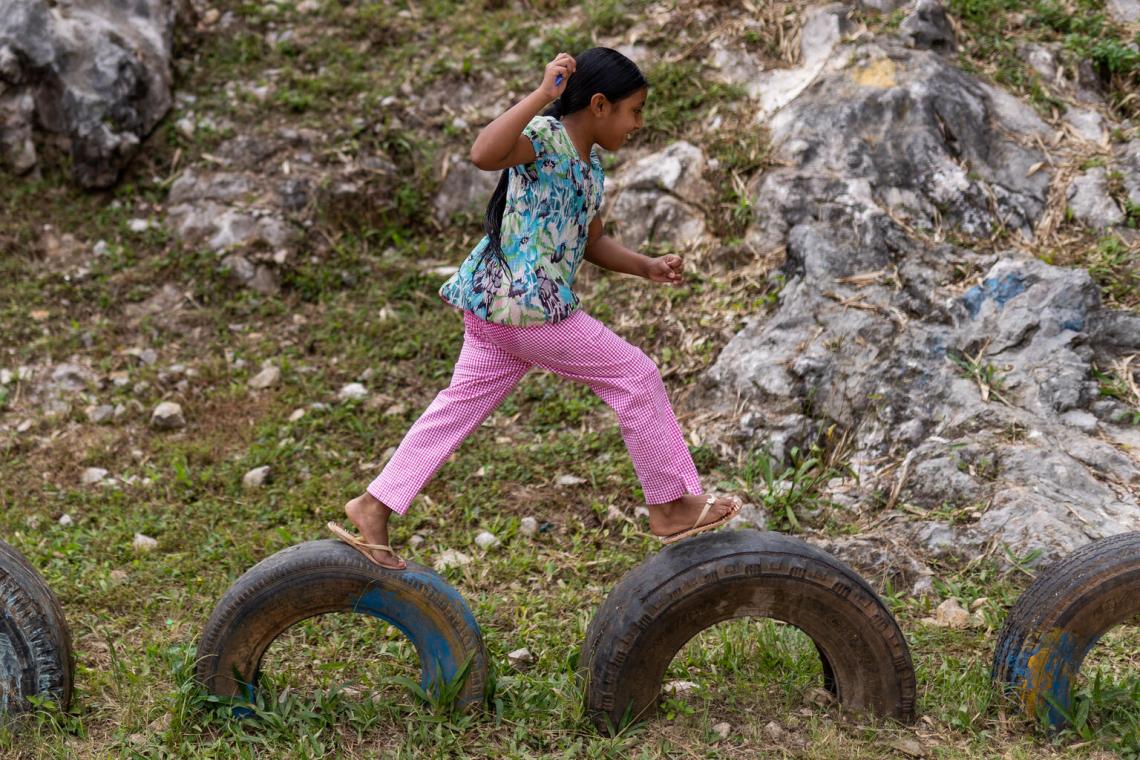 girl jumping over tires