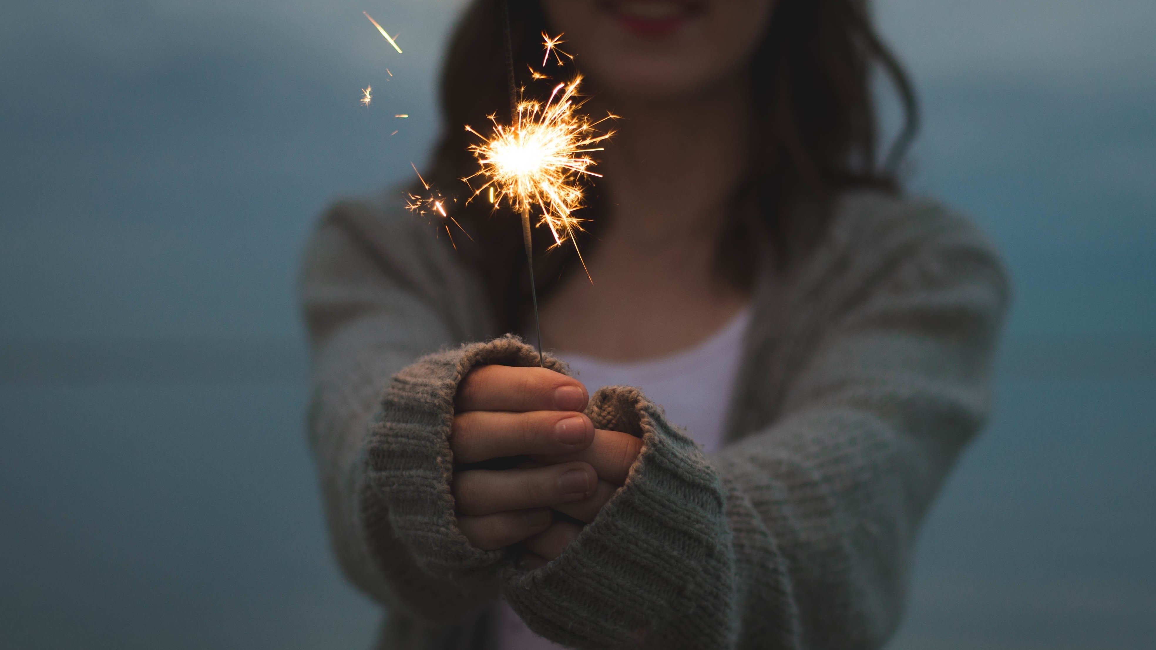 woman-holding-sparklers-in-dusk