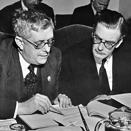 Herbert Vere Evatt (at left) and Anthony Eden (at right) seated, and looking at text.