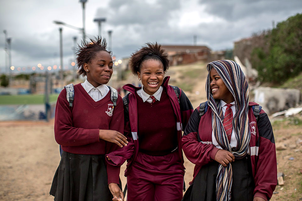 Girls in school uniform smile.