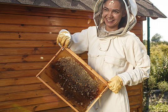woman beekeeper with honeycomb