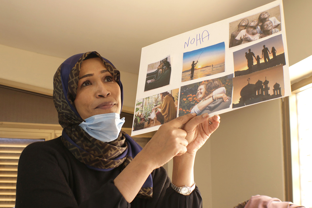 A woman holds up a photo collage.
