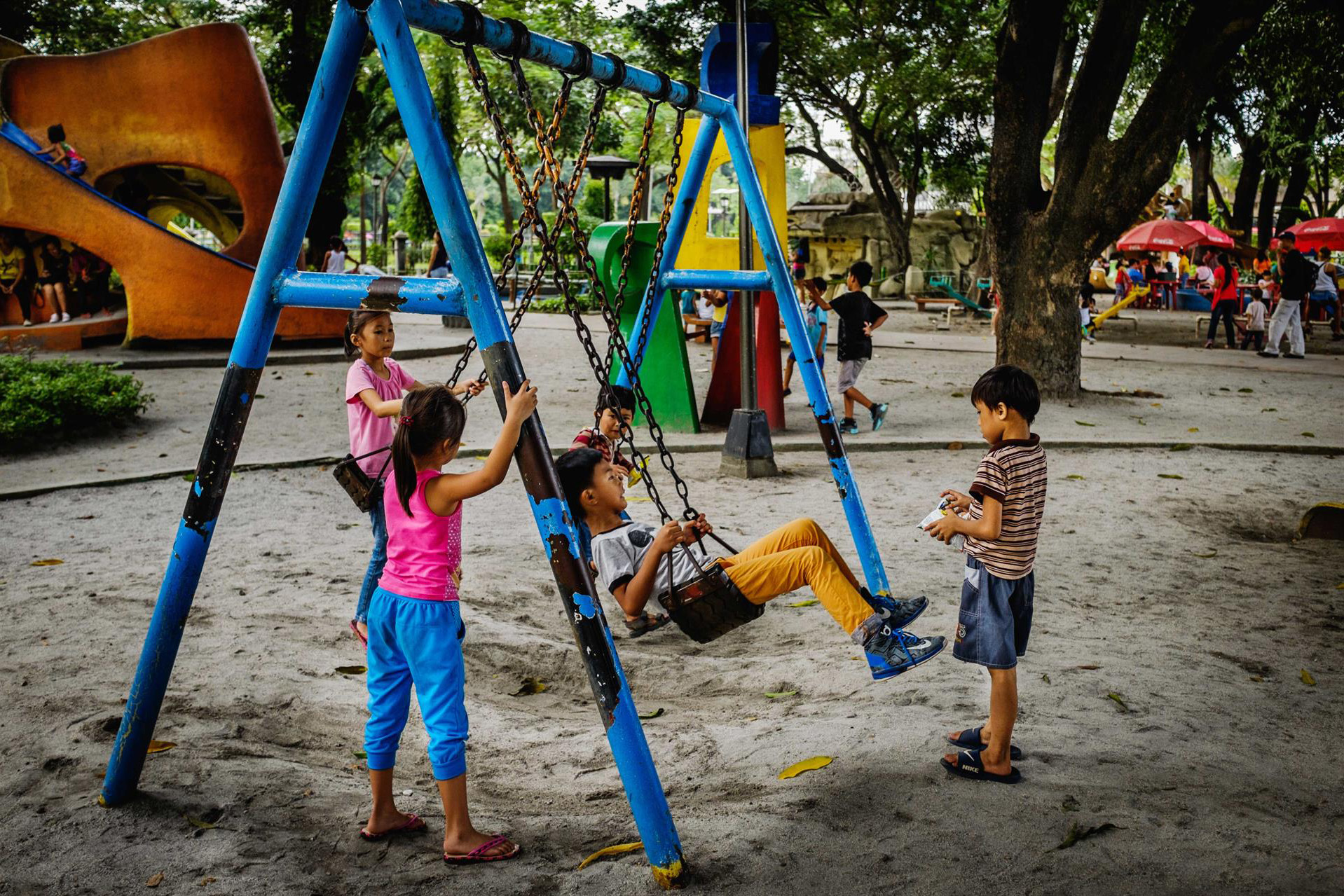 Children playing on swings at a playground.