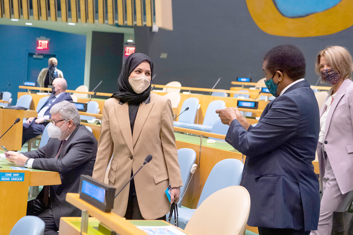 People wearing facemasks talking at the General Assembly.