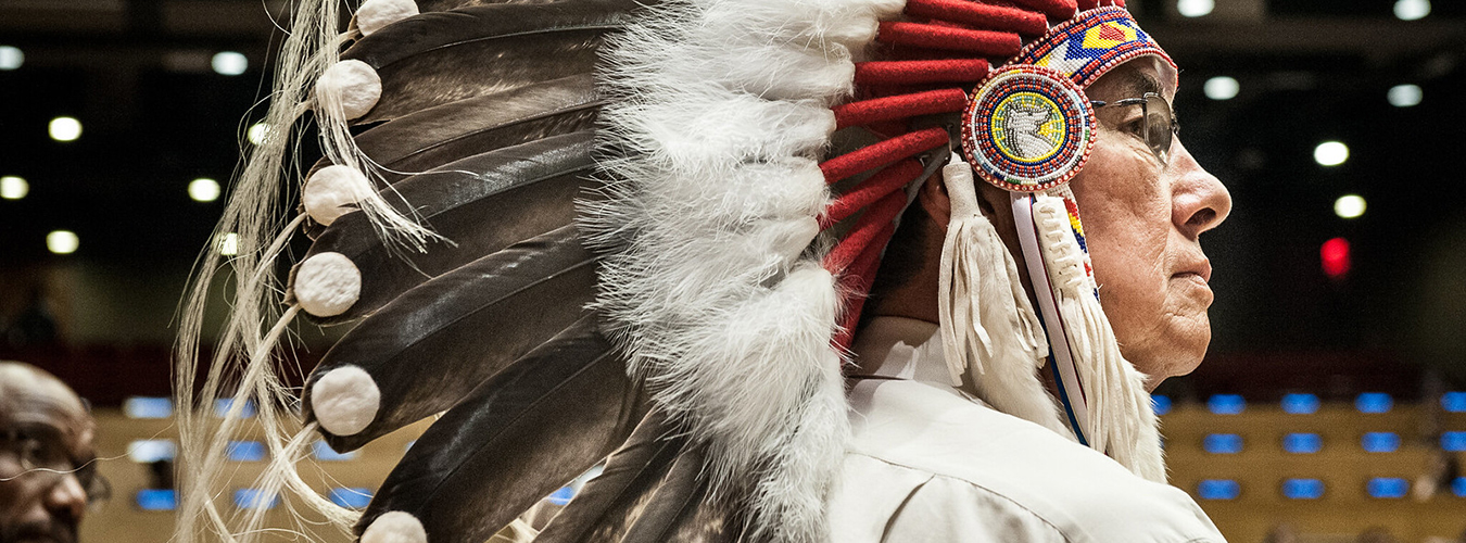 Foto de perfil del Gran Jefe Wilton Littlechild, un Jefe Cree de Canadá, con su tocado tradicional.
