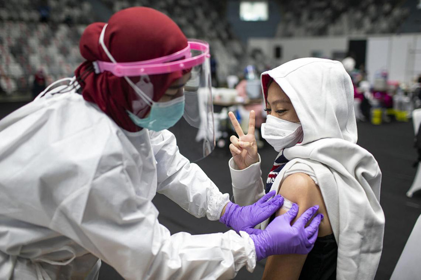 woman showing peace sign after getting vaccine